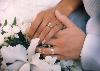 bride and groom holding hands showing rings